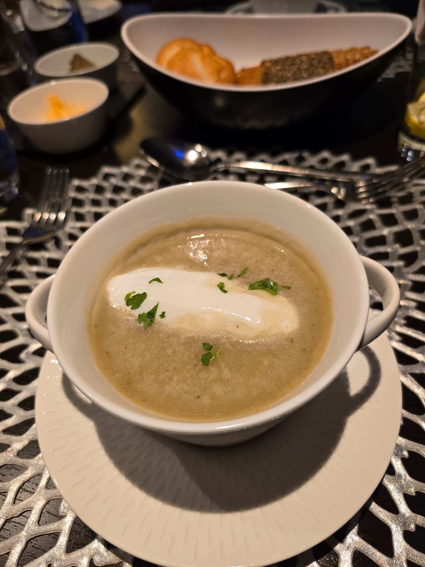 A bowl of Avalon's cream of asparagus soup topped with cream and fresh herbs