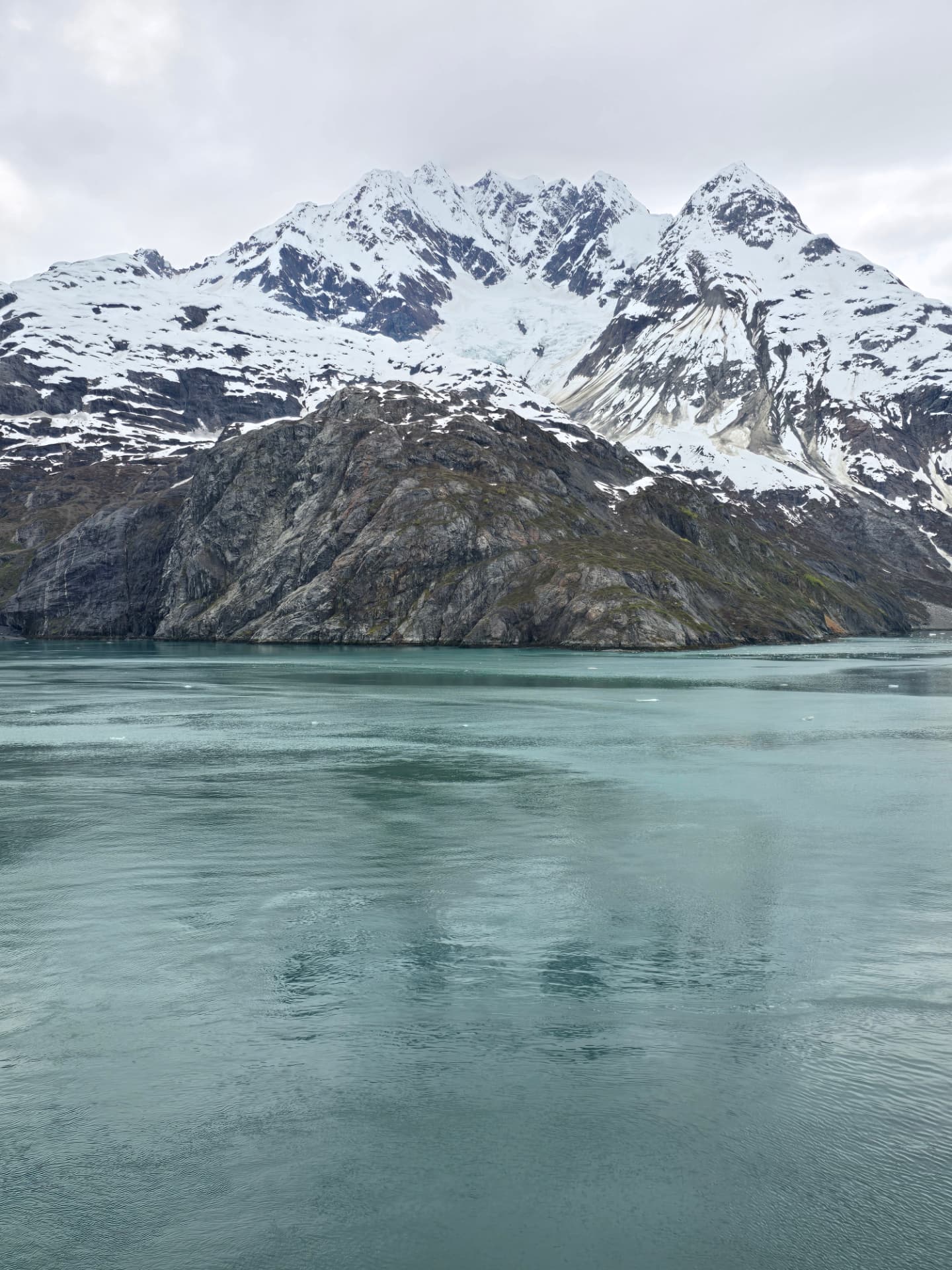 Gina Renée's view of a glacier between snow-covered Alaska mountains