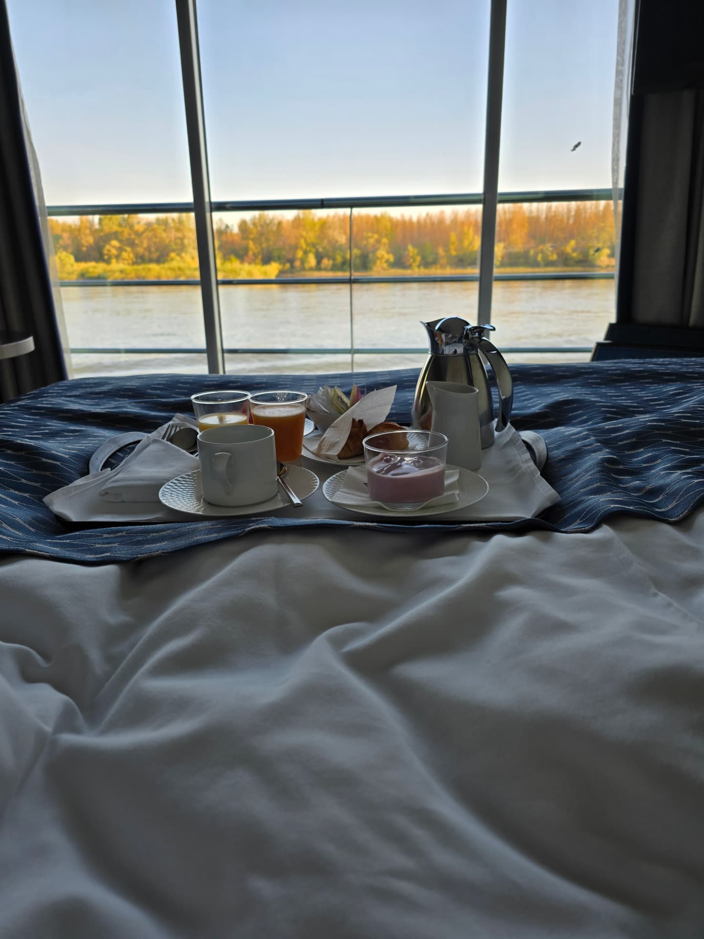 Breakfast served in bed in Gina and Lloyd's Avalon Panorama Suite, with the river visible through the panoramic window
